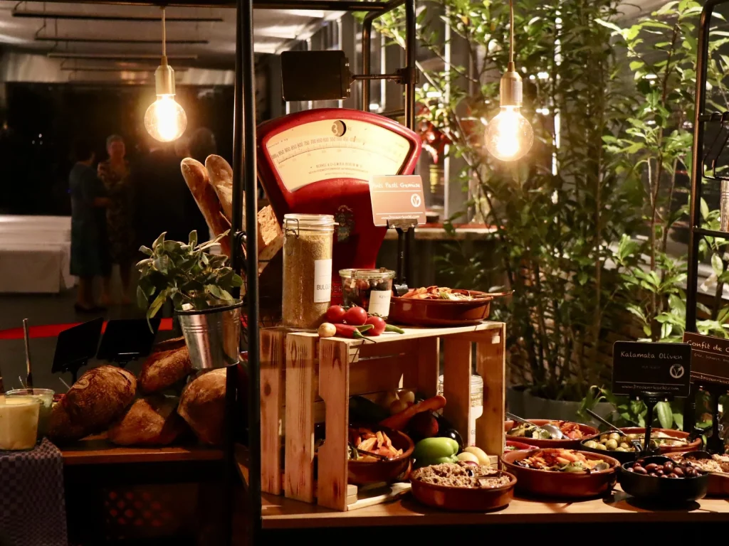Übersicht eines Catering-Buffets mit Pflanzen und Lichterketten dekoriert