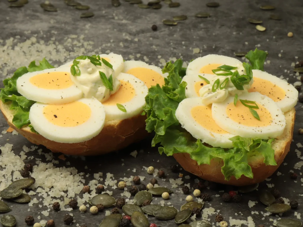Belegtes Brötchen mit Eierscheiben, Salat und Schnittlauch als Fingerfood