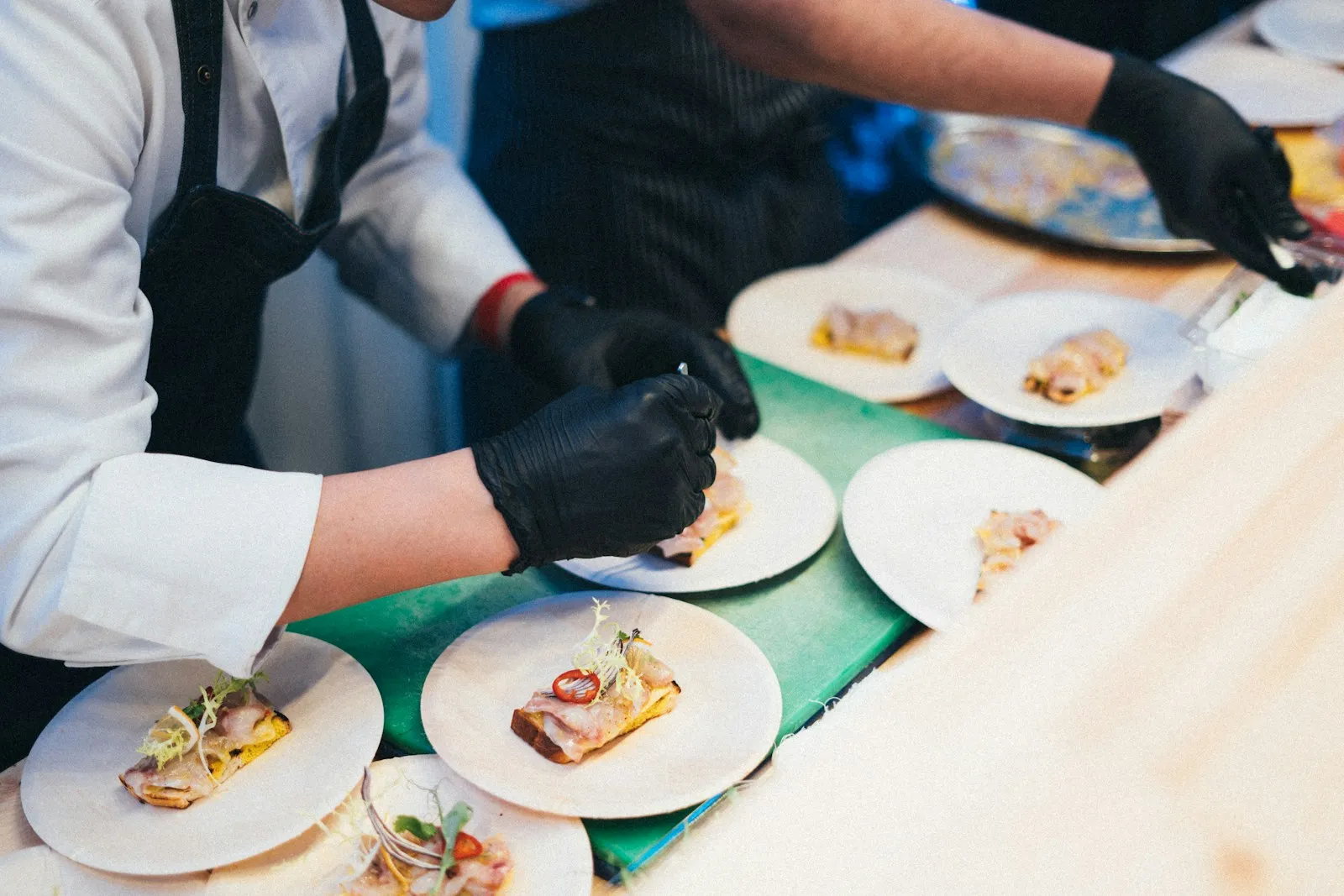Servicepersonal richtet Teller beim Sommerfest Catering an